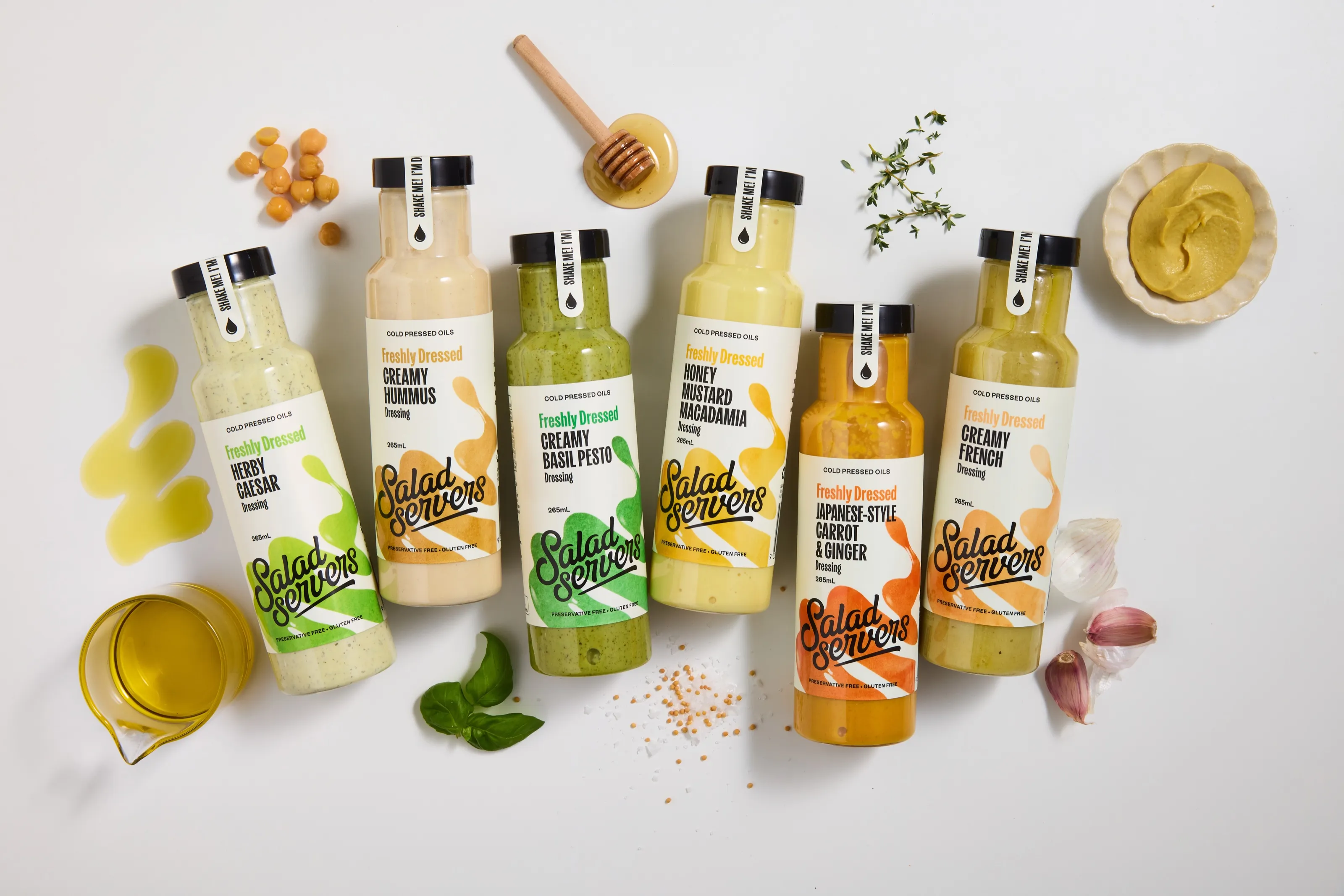 All six Freshly Dressed bottles laid out with fresh ingredients