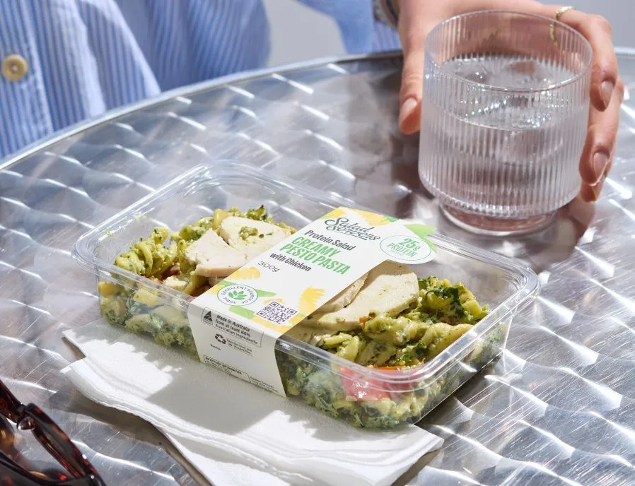 A Salad Servers Creamy Pesto Pasta protein salad with chicken on a cafe table
