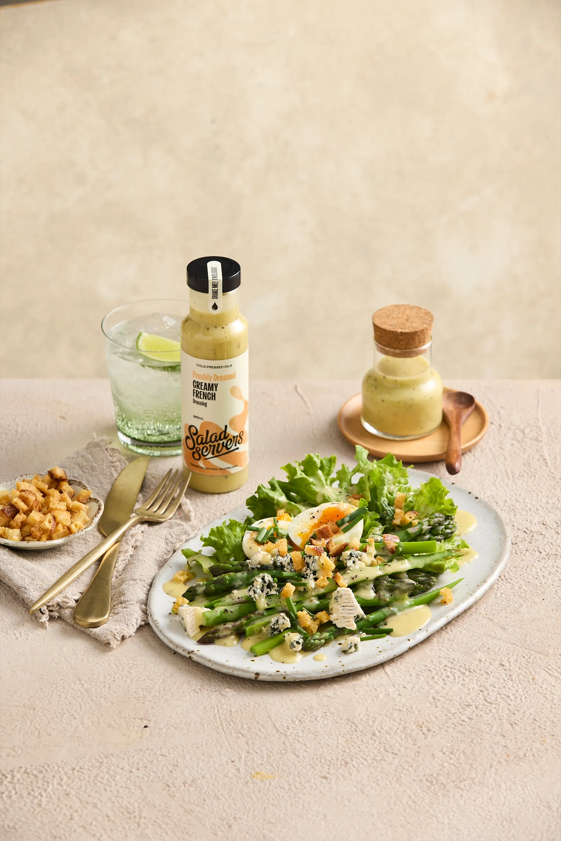 Asparagus, coral lettuce, boiled egg, blue cheese and croutons on a platter, drizzled with Salad Servers Creamy French dressing